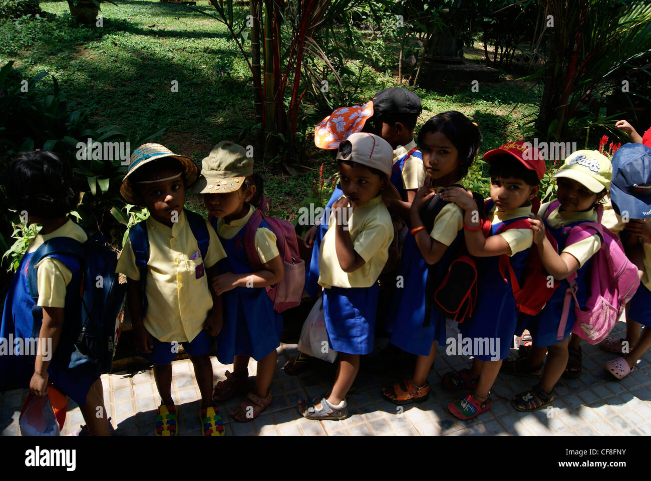 Small Nursery School Children standing in Queue for entering school Bus.A Scene from Kerala,India Stock Photo