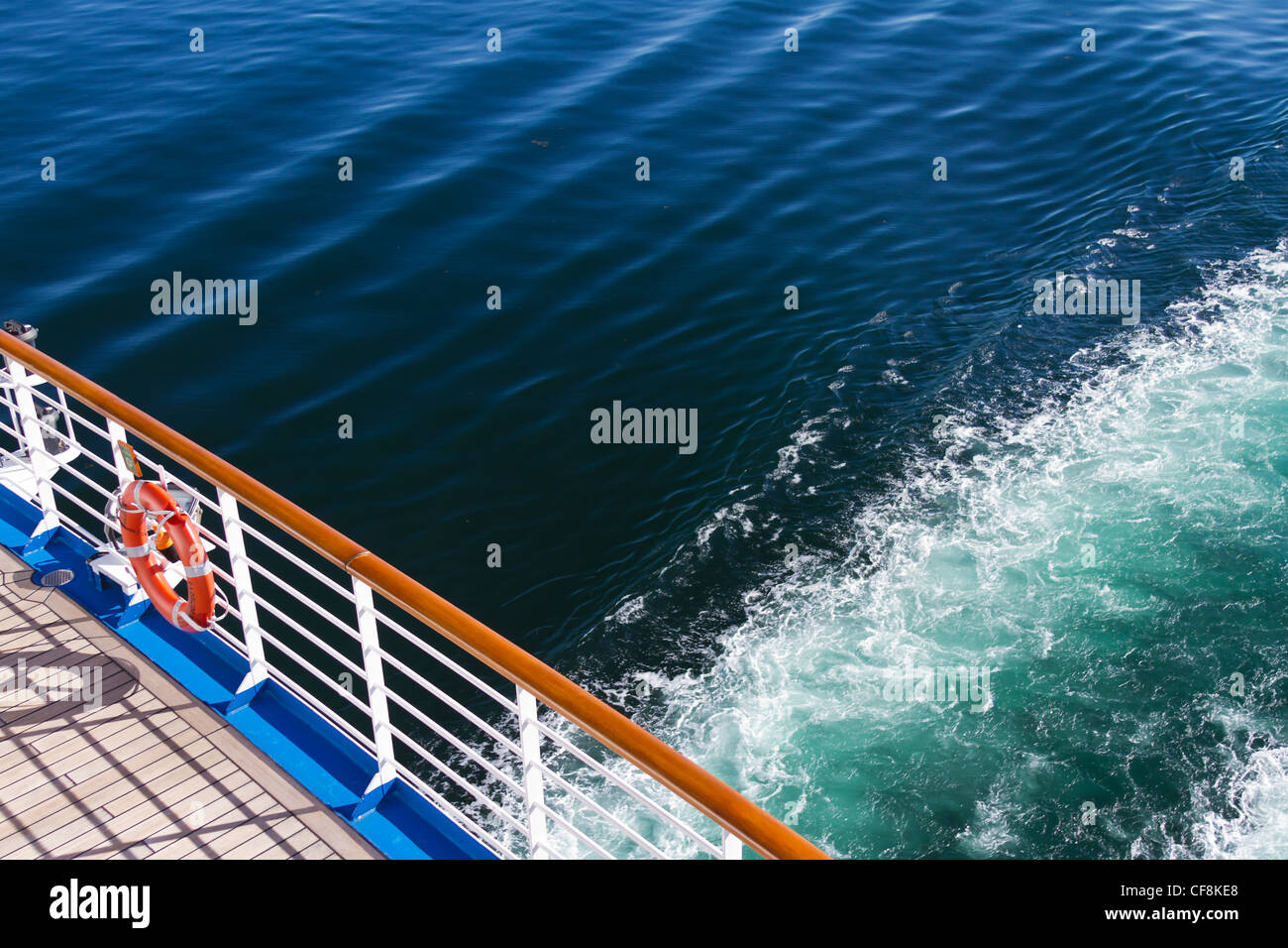 the balcony of a cruise ship with a wave pattern behind in the water, at sunset. Stock Photo