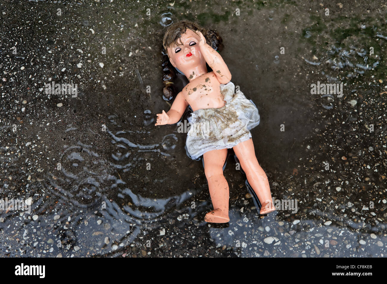 symbol of mistreatment and abuse of children. doll lying on the ground Stock Photo