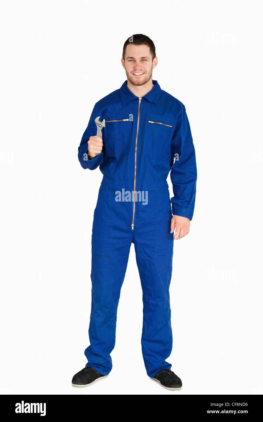 Smiling young mechanic in boiler suit with a wrench Stock Photo