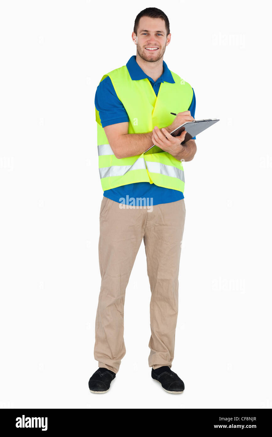 Smiling young male with safety jacket taking notes Stock Photo