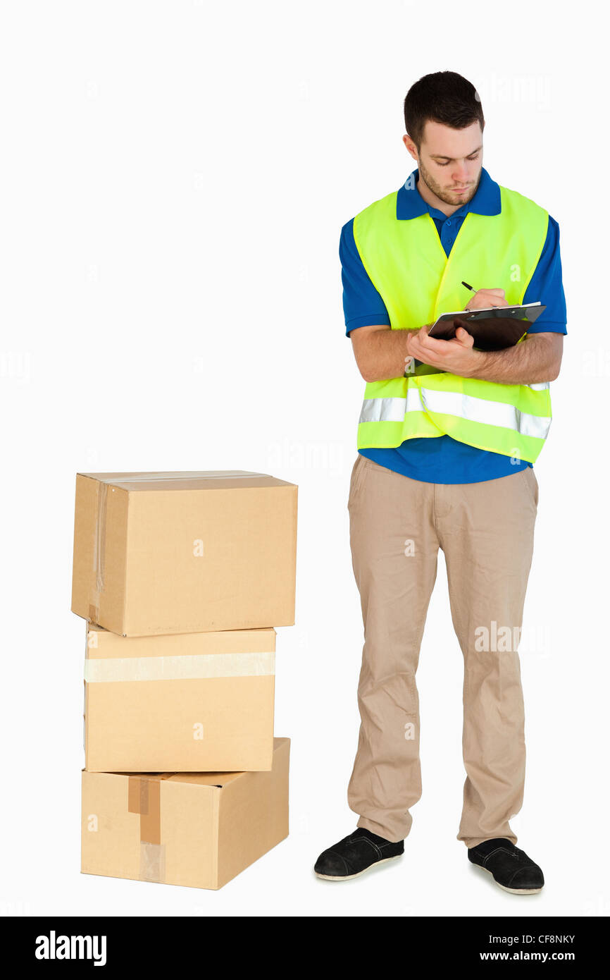 Young delivery man completing delivery note Stock Photo Alamy