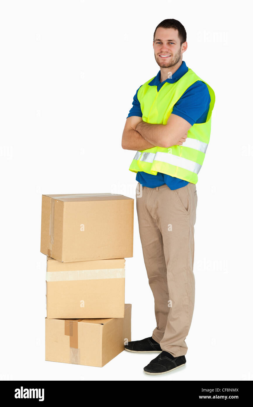 Smiling young delivery man with arms folded Stock Photo - Alamy