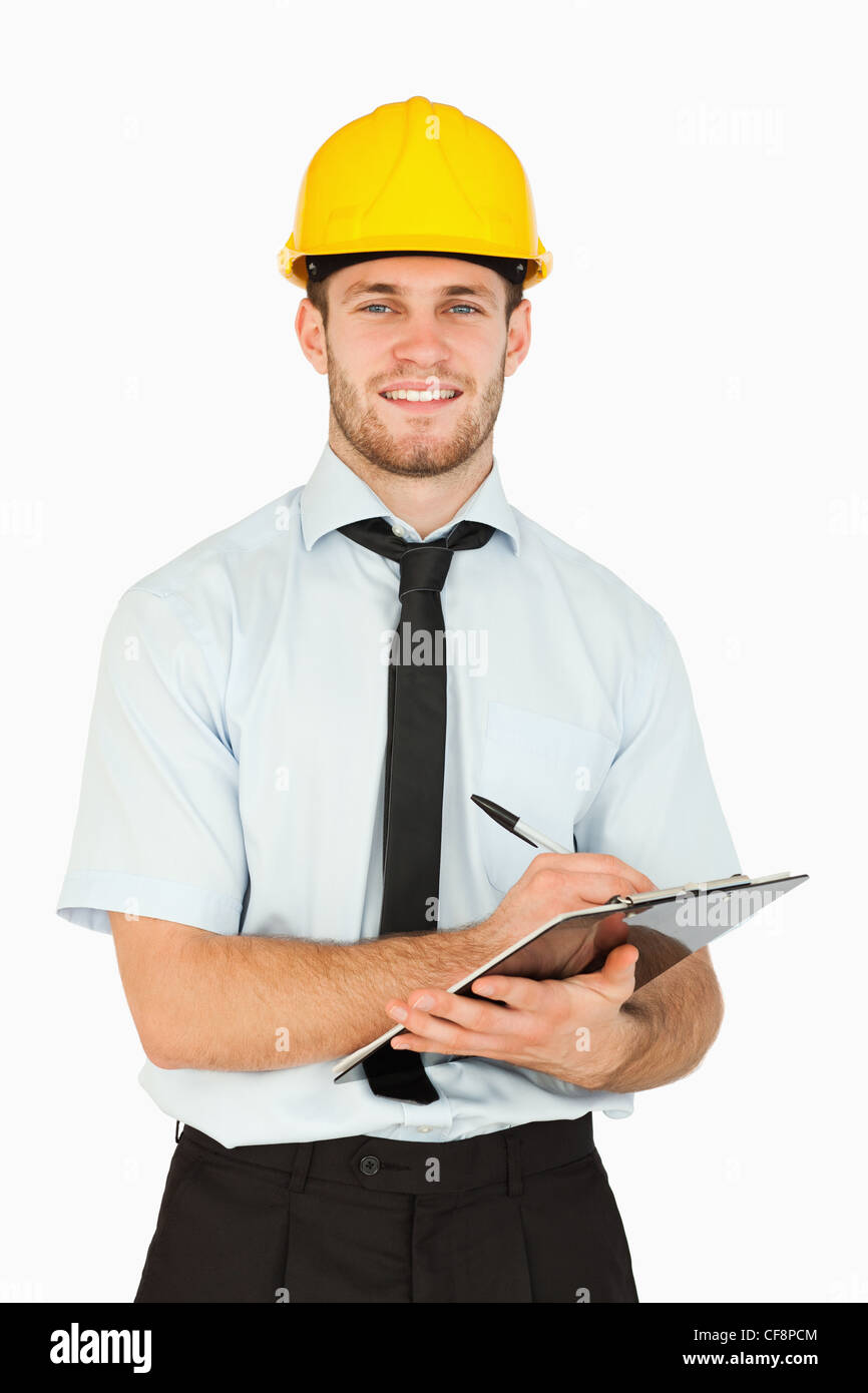 Smiling young lead worker taking notes on his clipboard Stock Photo - Alamy