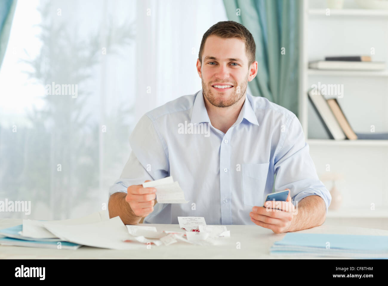 Businessman with pocket calculator checking bills Stock Photo