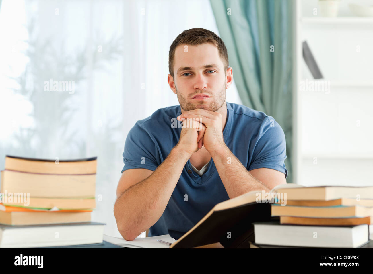 Student sitting at his desk thinking Stock Photo