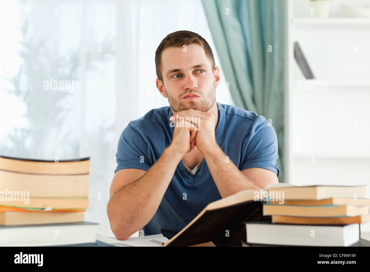 Student sitting at his desk in thoughts Stock Photo