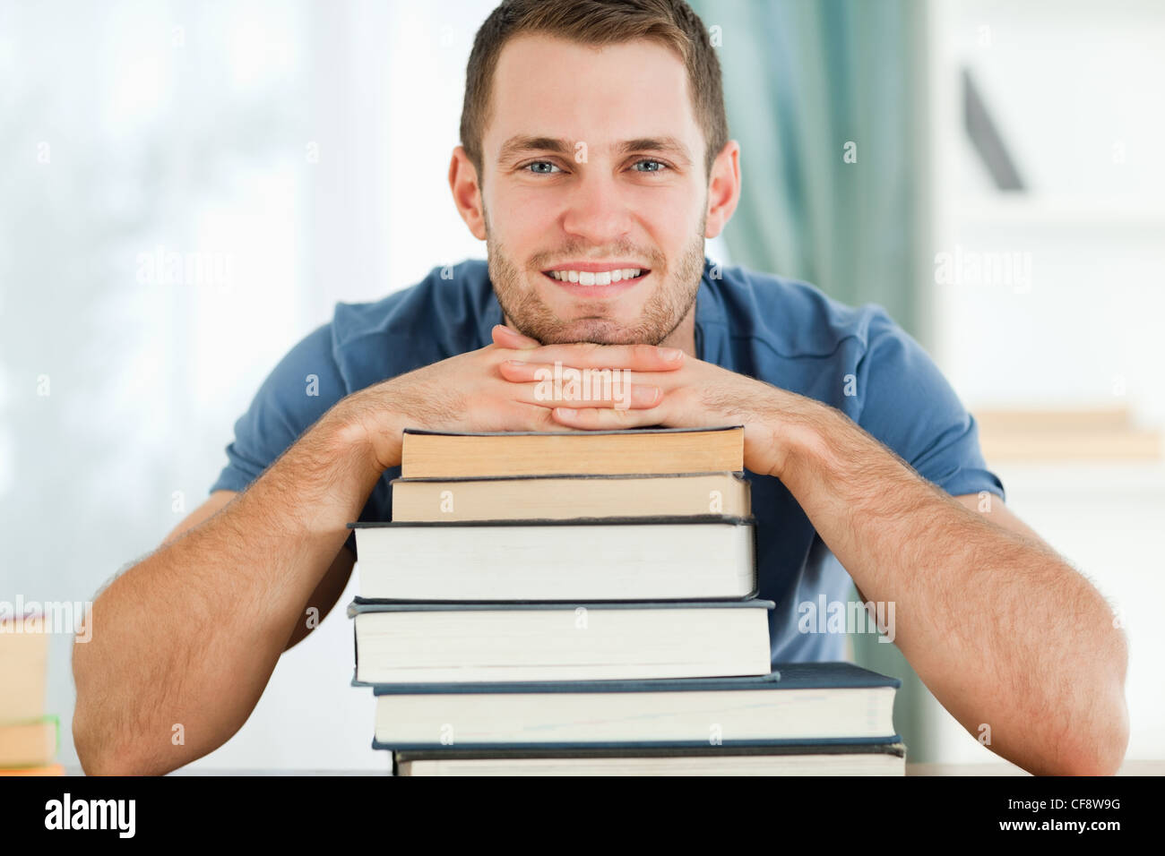 Smiling student leaning on his books Stock Photo - Alamy