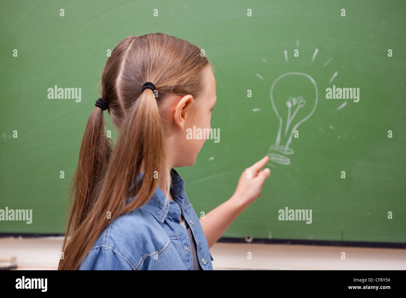 Schoolgirl pointing at a bulb Stock Photo
