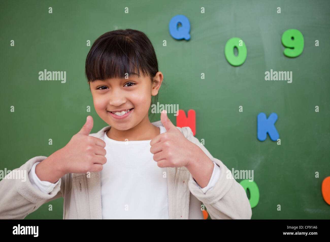 Happy schoolgirl with the thumbs up Stock Photo - Alamy