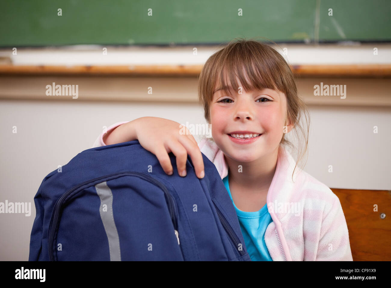Smiling schoolgirl posing with a bag Stock Photo - Alamy