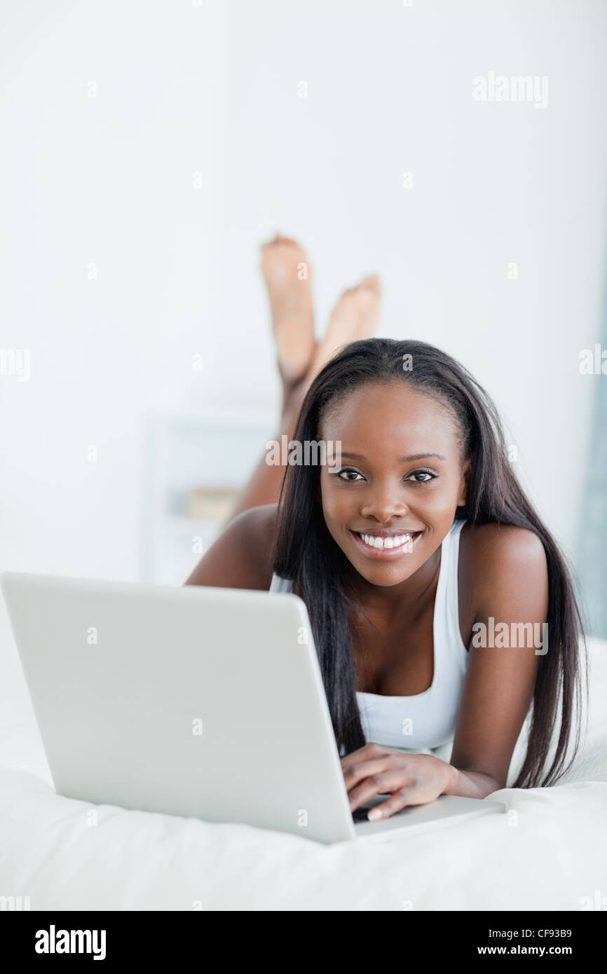 Portrait of a woman lying on her belly with a laptop Stock Photo - Alamy