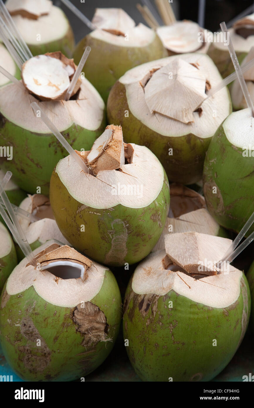 coconuts prepared for drinking at market stall Stock Photo Alamy