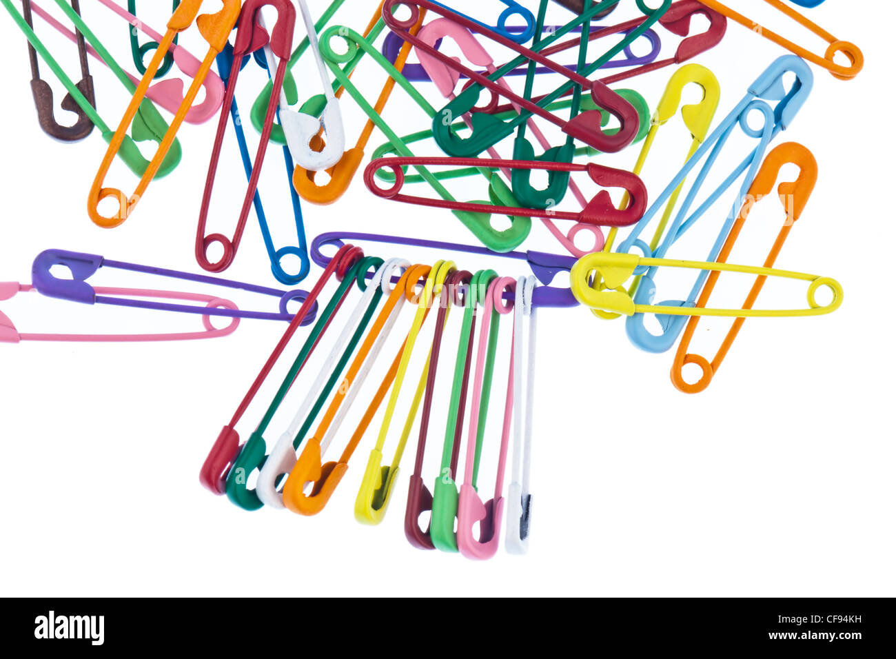 lots of colorful safety pin lying on a white background Stock Photo