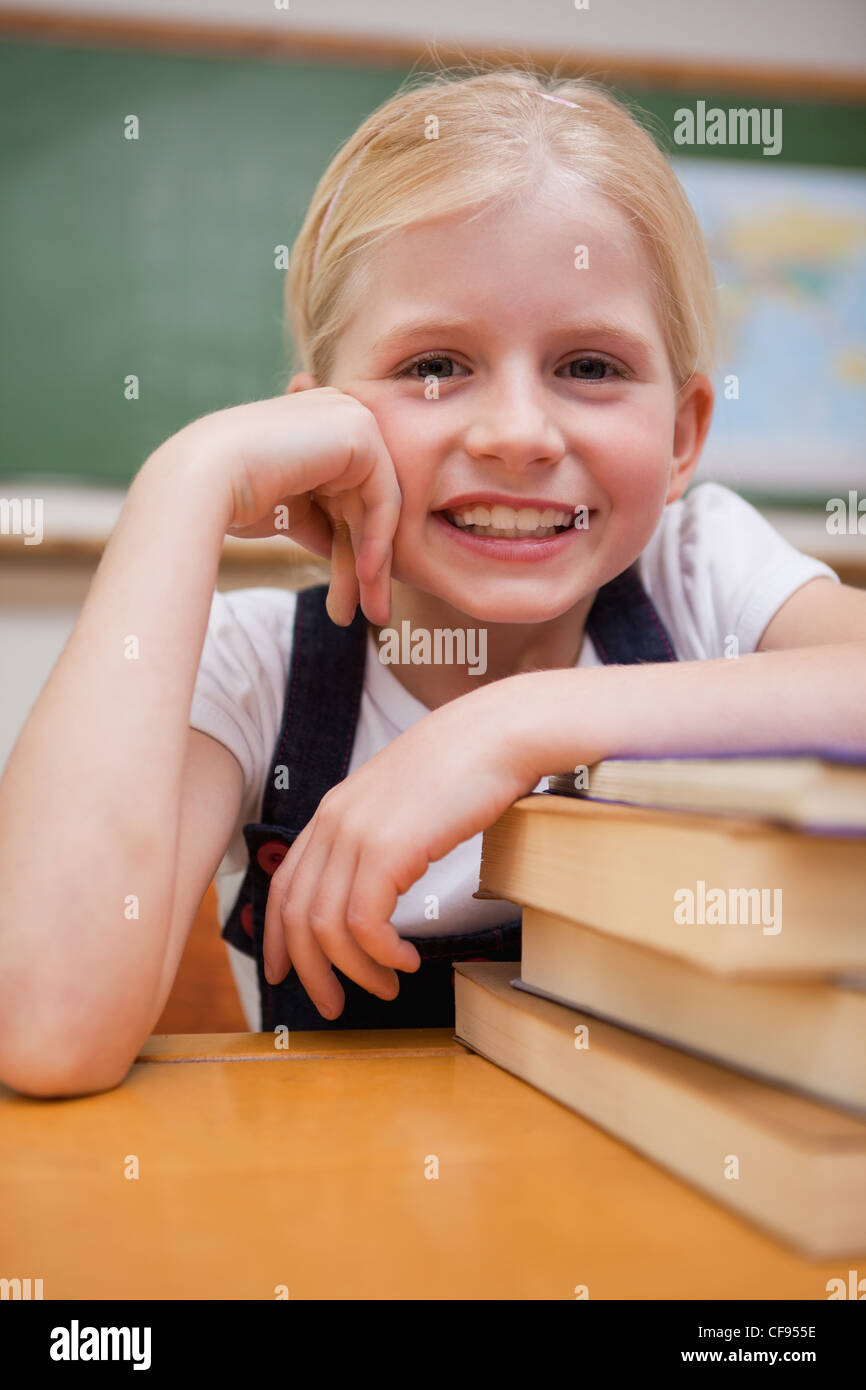 Portrait of a smiling girl leaning on books Stock Photo - Alamy