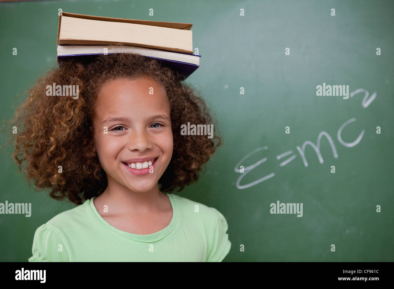 Happy schoolgirl holding her book on her head Stock Photo - Alamy