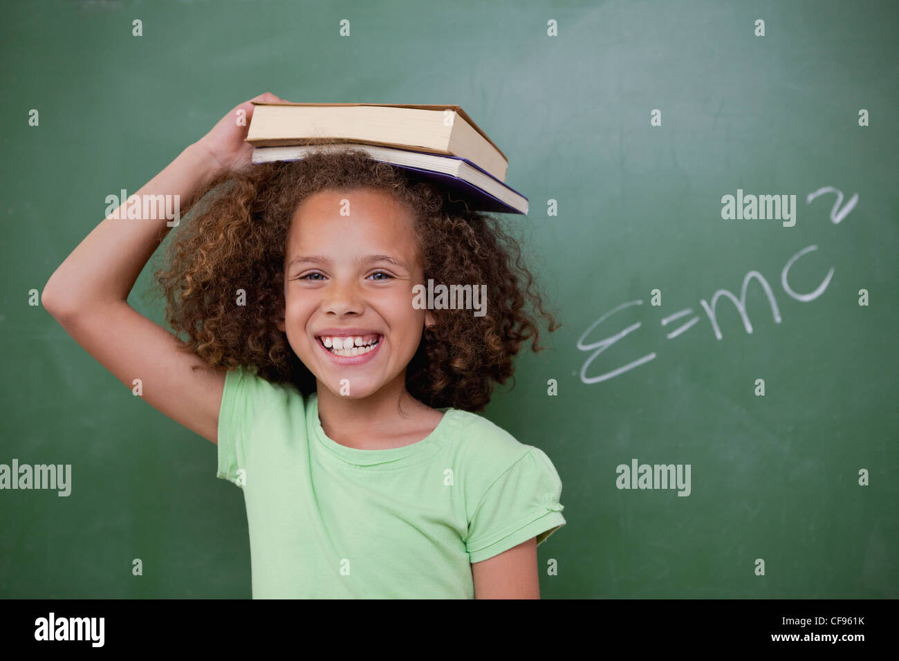 Cheerful schoolgirl holding her book on her head Stock Photo - Alamy