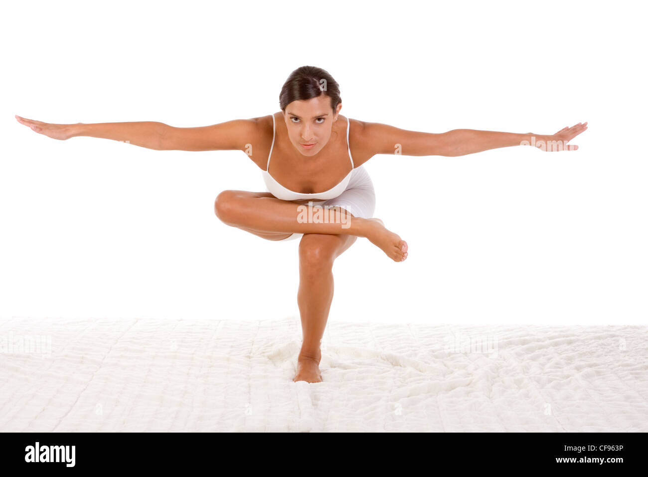 yoga pose 'Standing/Squatting pigeon' - female in sport clothes performing exercise Stock Photo