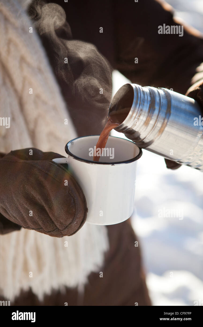 https://c8.alamy.com/comp/CF97FP/pouring-hot-chocolate-from-a-thermos-to-a-mug-on-a-winter-day-outdoors-CF97FP.jpg