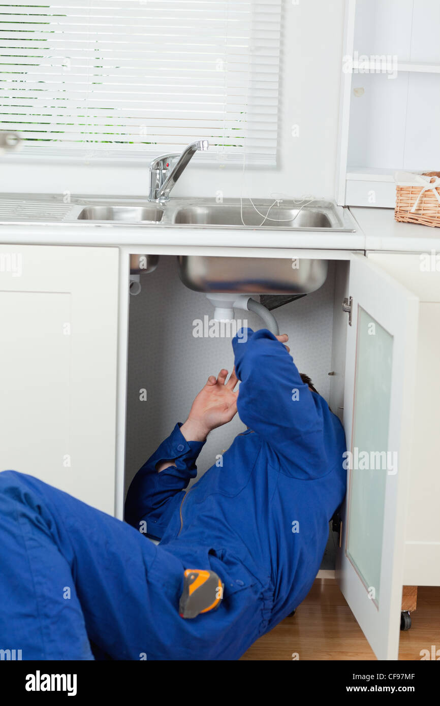 Portrait of a plumber fixing a sink Stock Photo