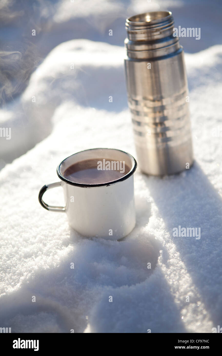Mug and thermos of hot chocolate on a cold winter day in snow Stock Photo -  Alamy