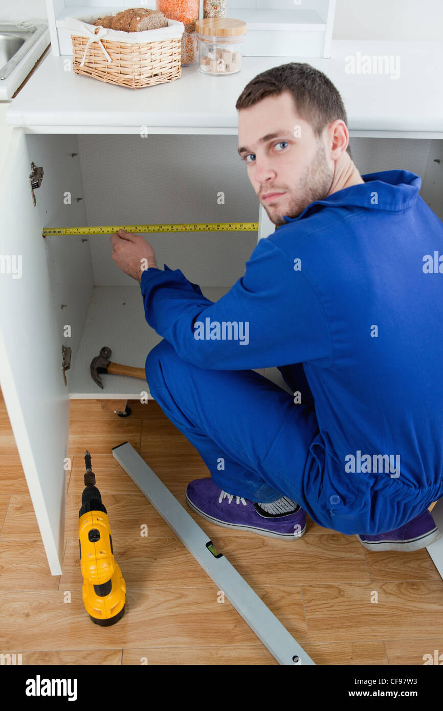 Portrait of a young repair man measuring something Stock Photo - Alamy