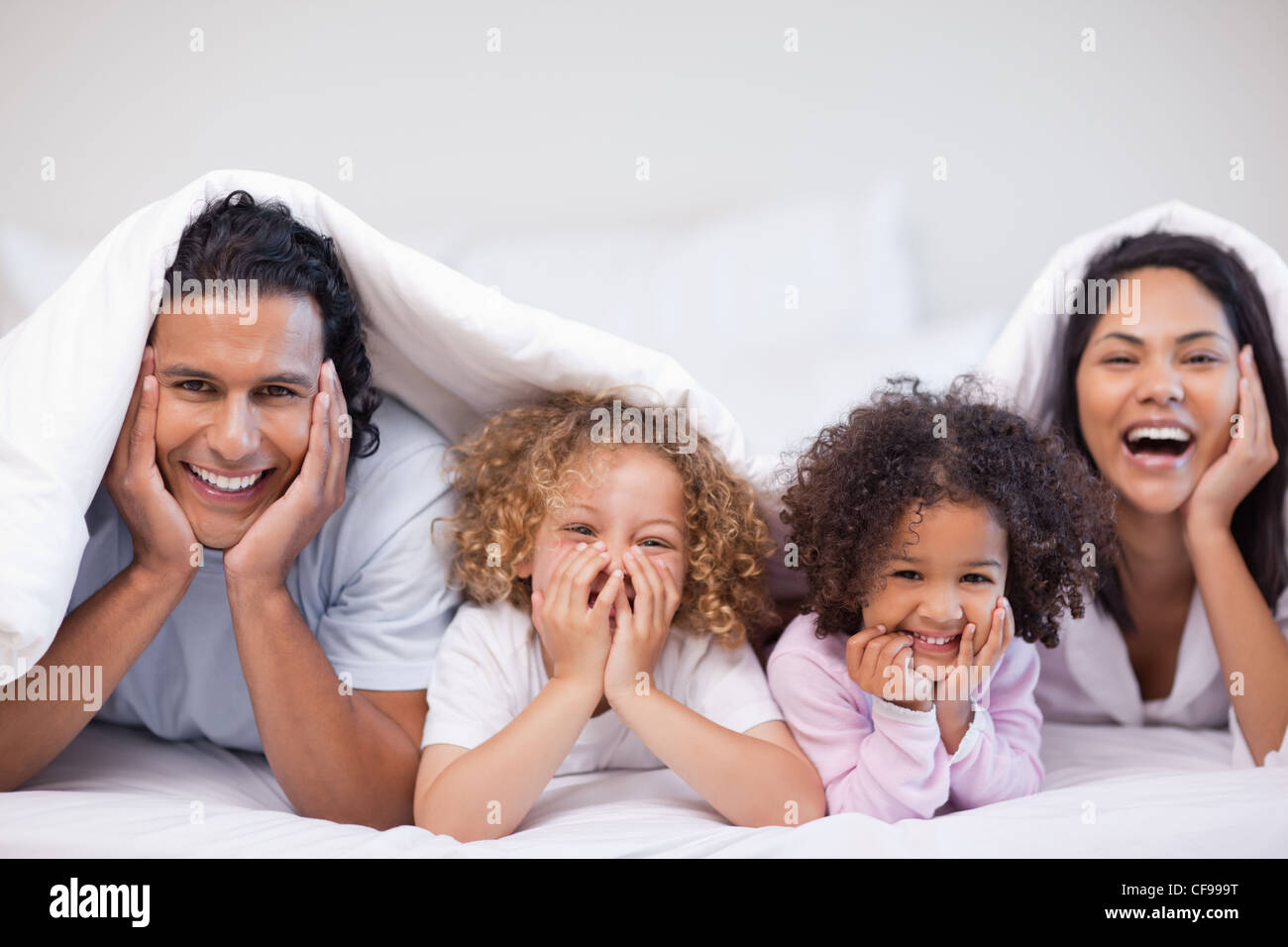 Joyful family hiding under the blanket Stock Photo Alamy