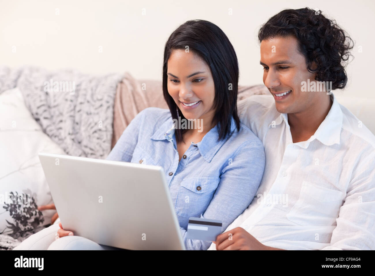 Couple with laptop on the couch Stock Photo - Alamy