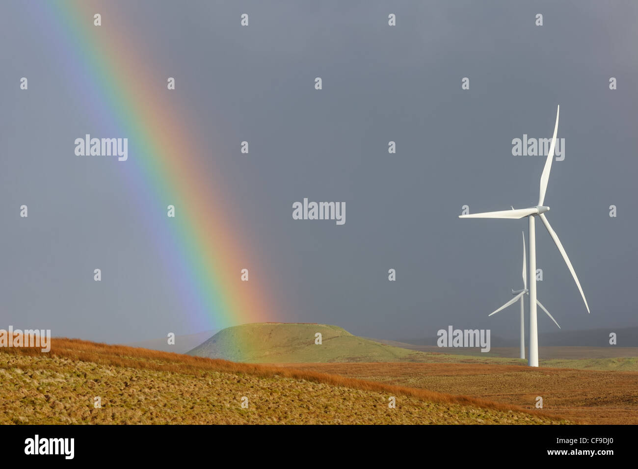 A rainbow adorns the skyline on the Eaglesham moor beside the wind turbines of Whitelees. Stock Photo