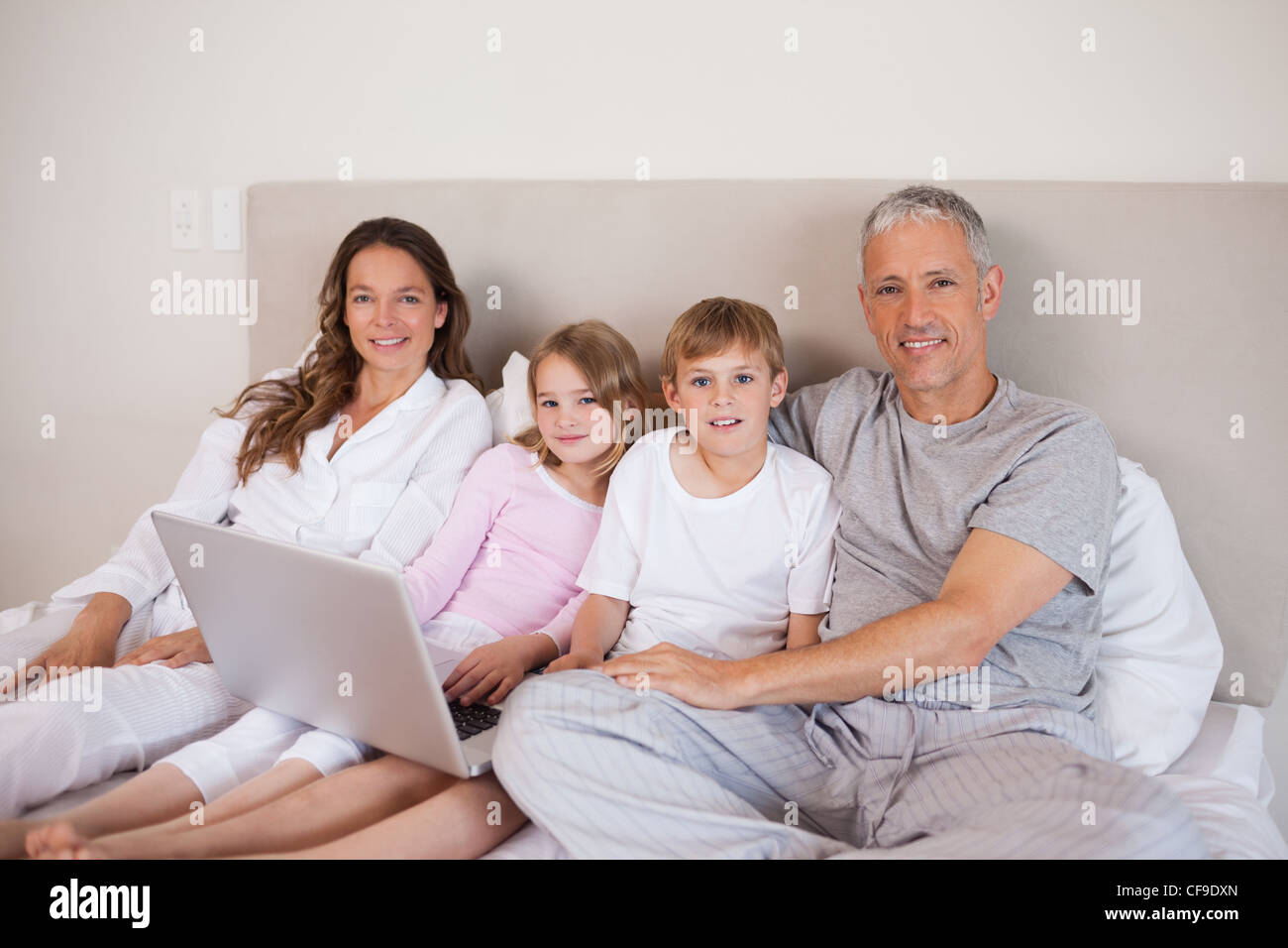 Smiling family using a laptop Stock Photo - Alamy
