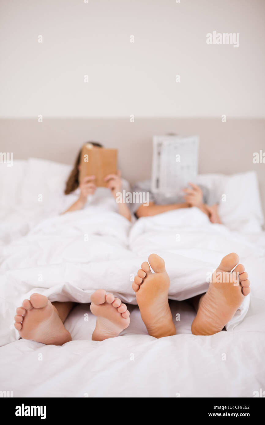 Portrait of woman reading a book while her companion is reading the news Stock Photo