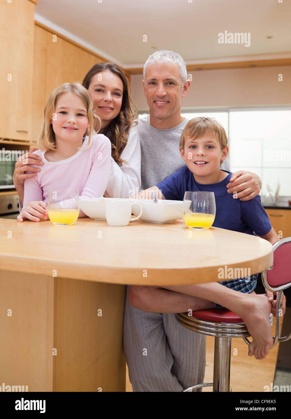 Portrait of a smiling family having breakfast Stock Photo - Alamy