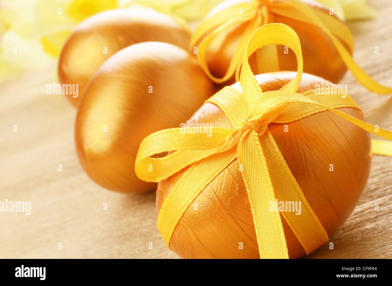 Easter eggs with bows on gold over floral background Stock Photo - Alamy