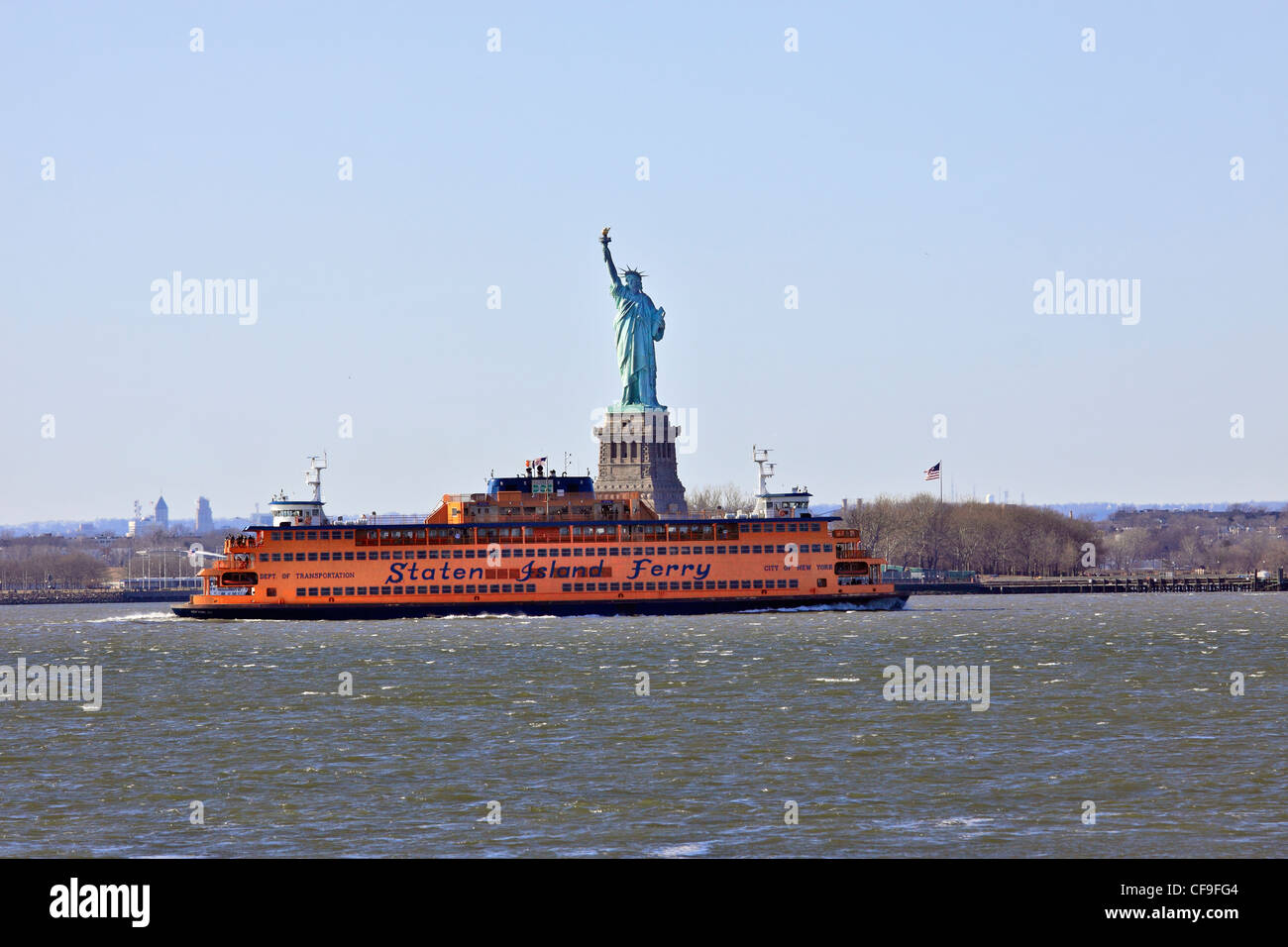 The Staten Island Ferry passes in front of the Statue of Liberty in New