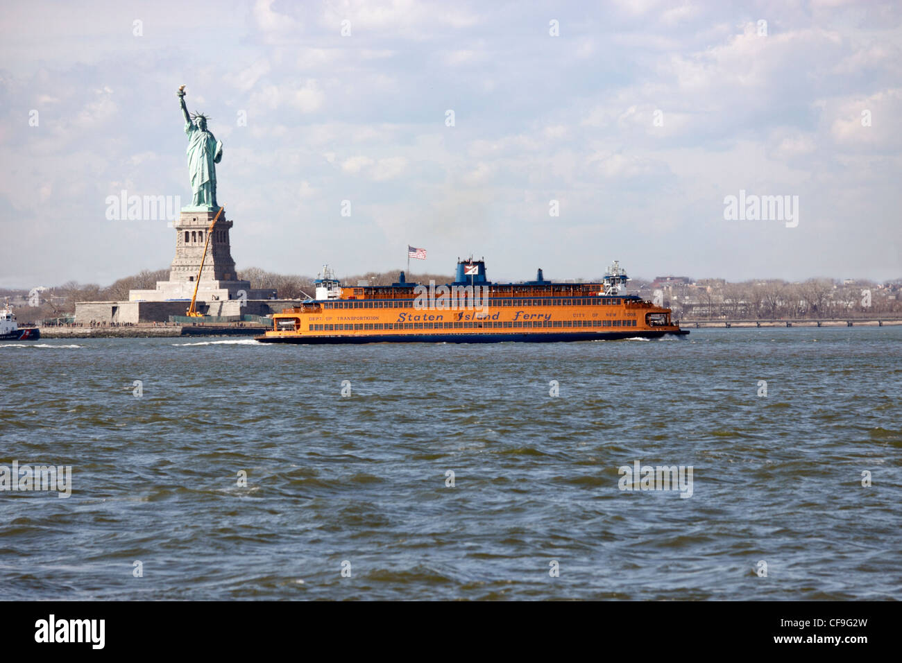 The Staten Island Ferry passes in front of the Statue of Liberty in New York Harbor viewed from