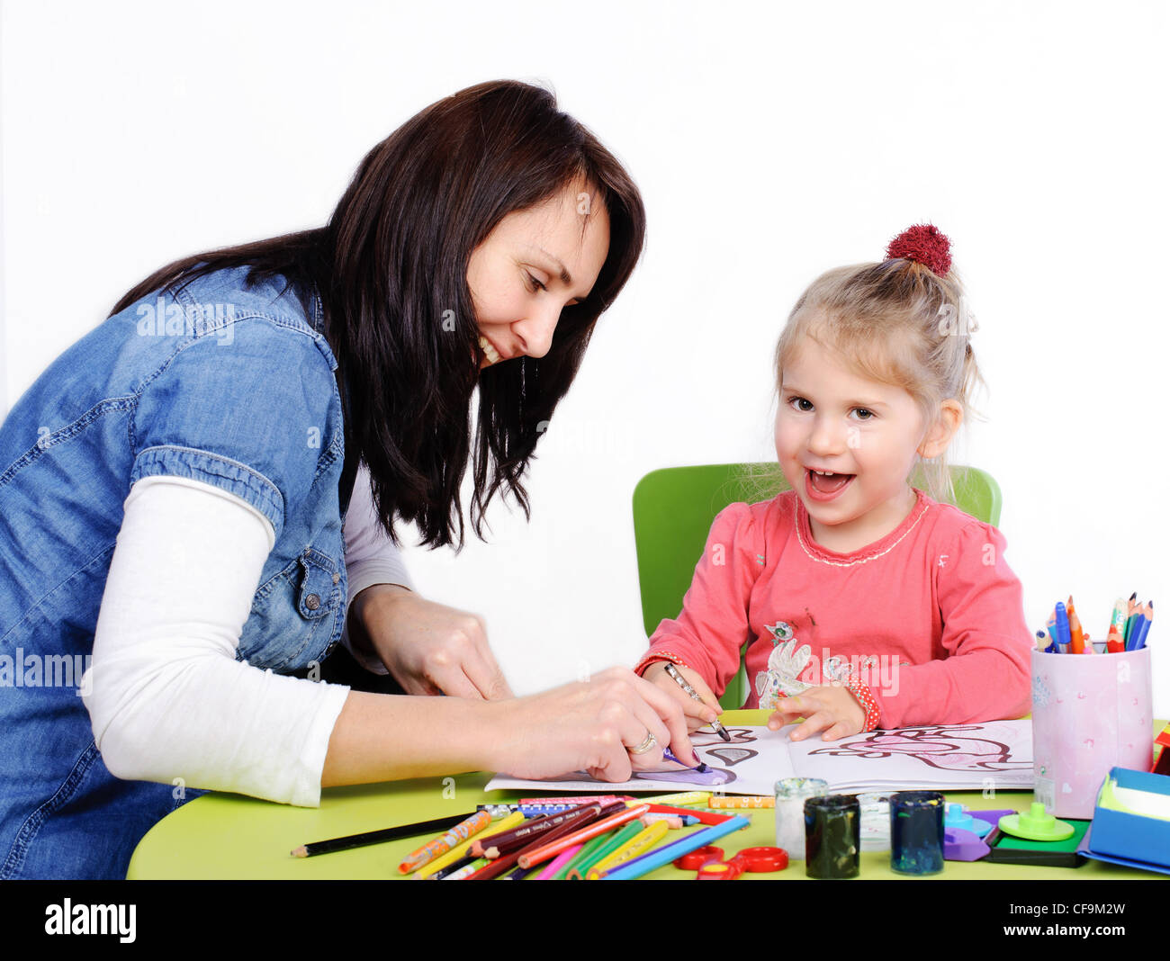Child painting , mother help by little girl. Stock Photo