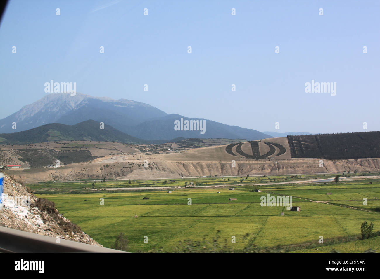 Allah emblem in trees in Iranian countryside with rice paddy fields and ...