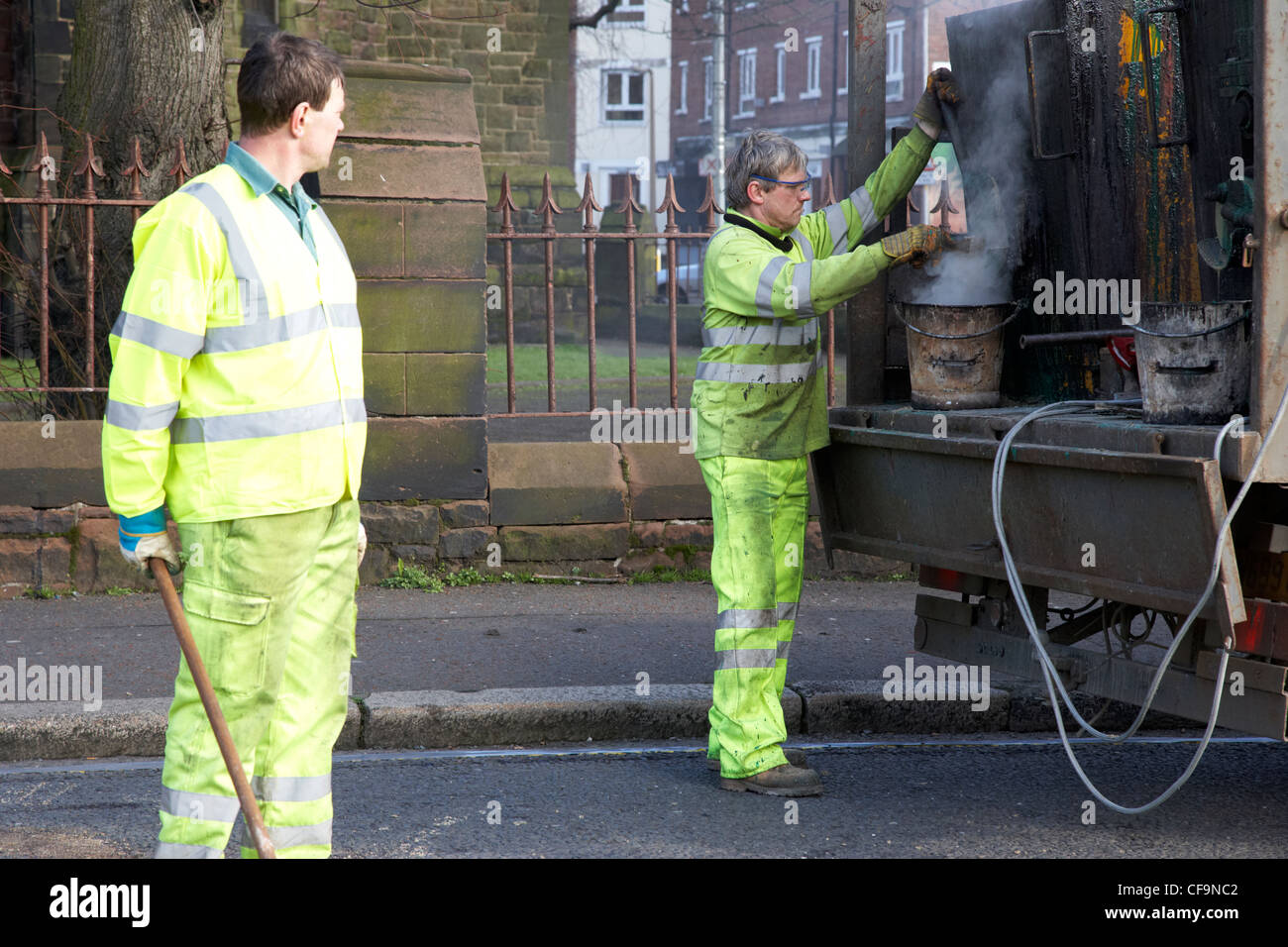 road construction workers installing hot applied high friction road surfacing Belfast Northern Ireland UK Stock Photo