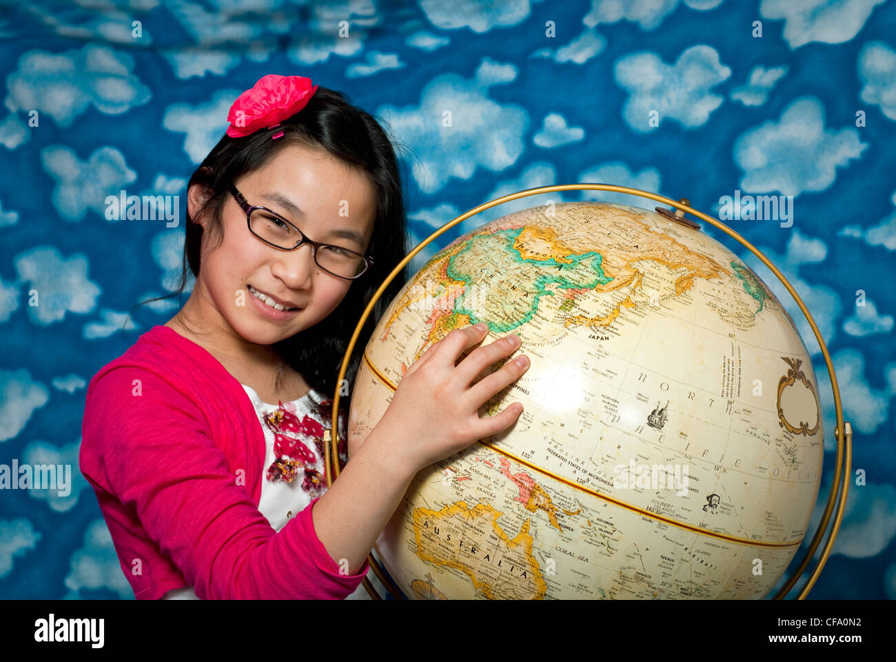 China is pointed to by a young girl on a globe Stock Photo