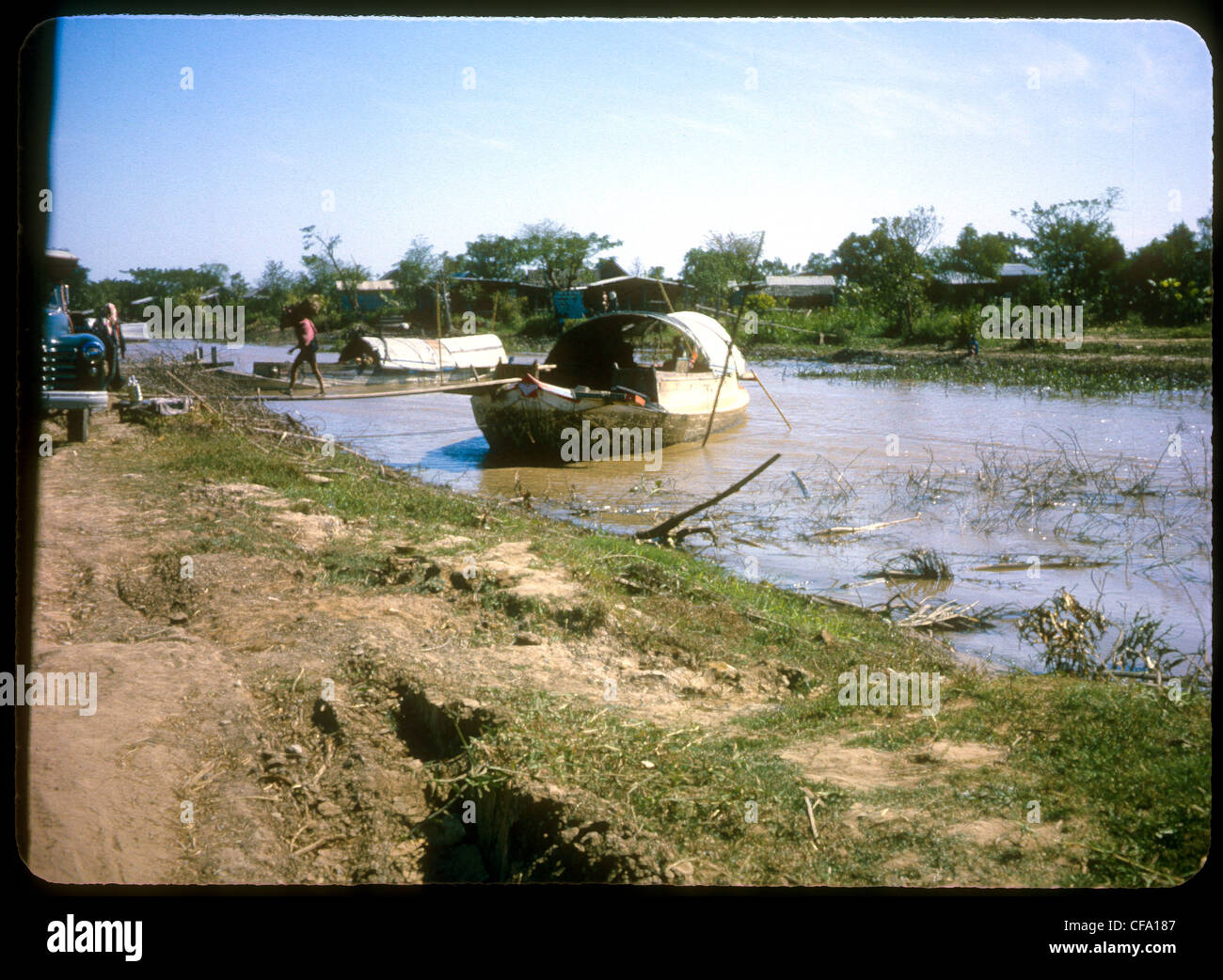 Boats parked anchored in small river during Vietnam War sampan Stock Photo