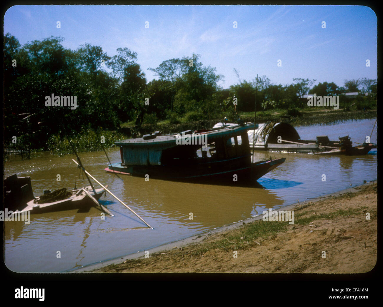 Boats parked anchored in small river during Vietnam War Stock Photo
