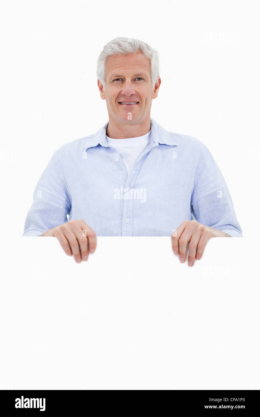 Portrait of a mature man standing behind blank board Stock Photo