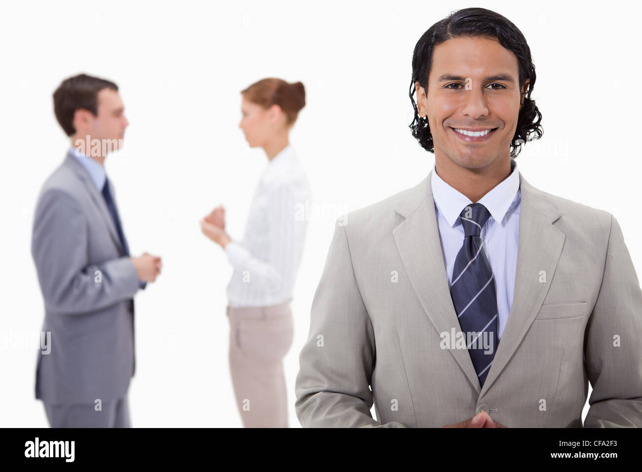 Businessman with talking colleagues behind him Stock Photo - Alamy