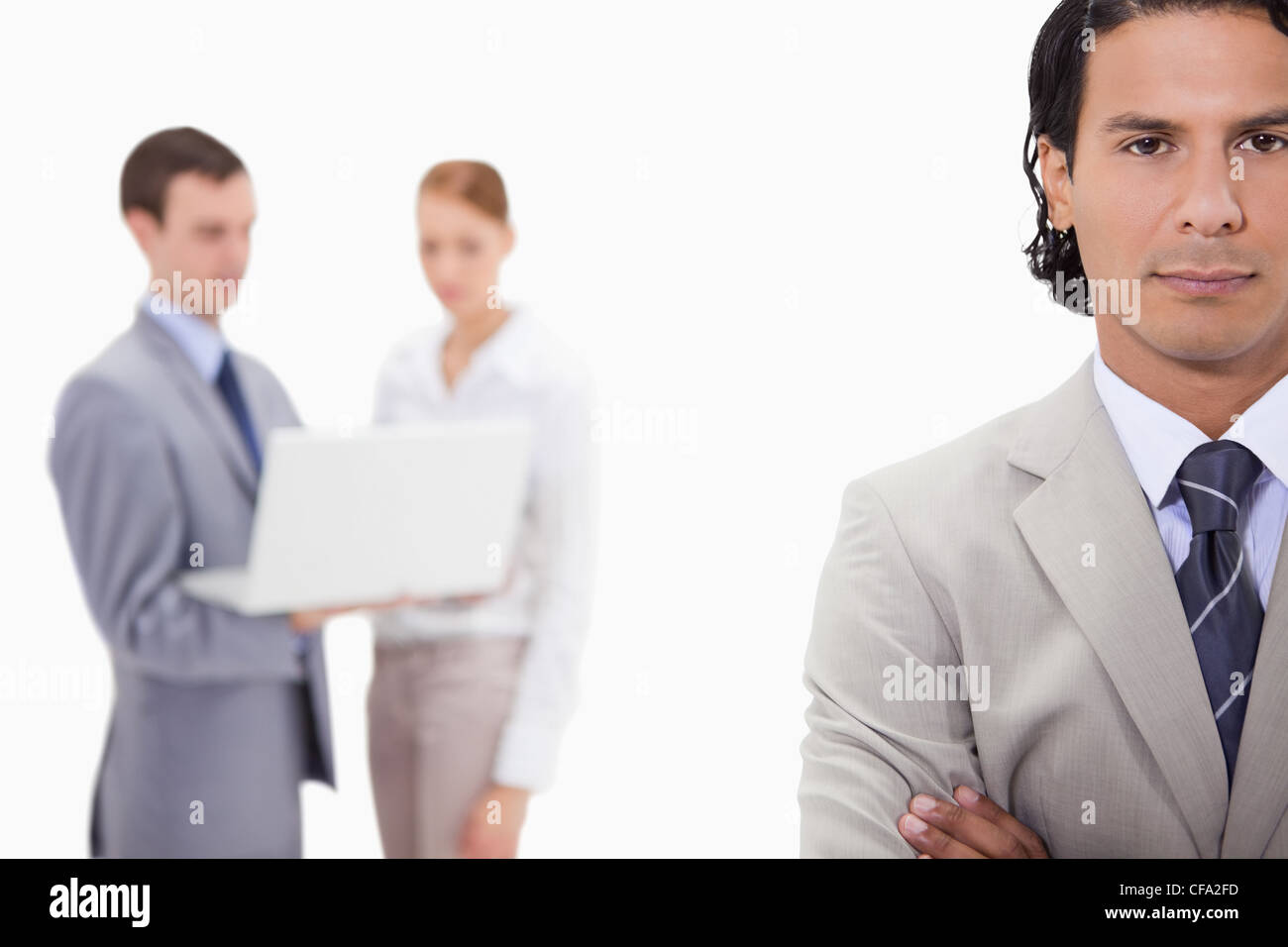 Businessman with colleagues with laptop behind him Stock Photo - Alamy