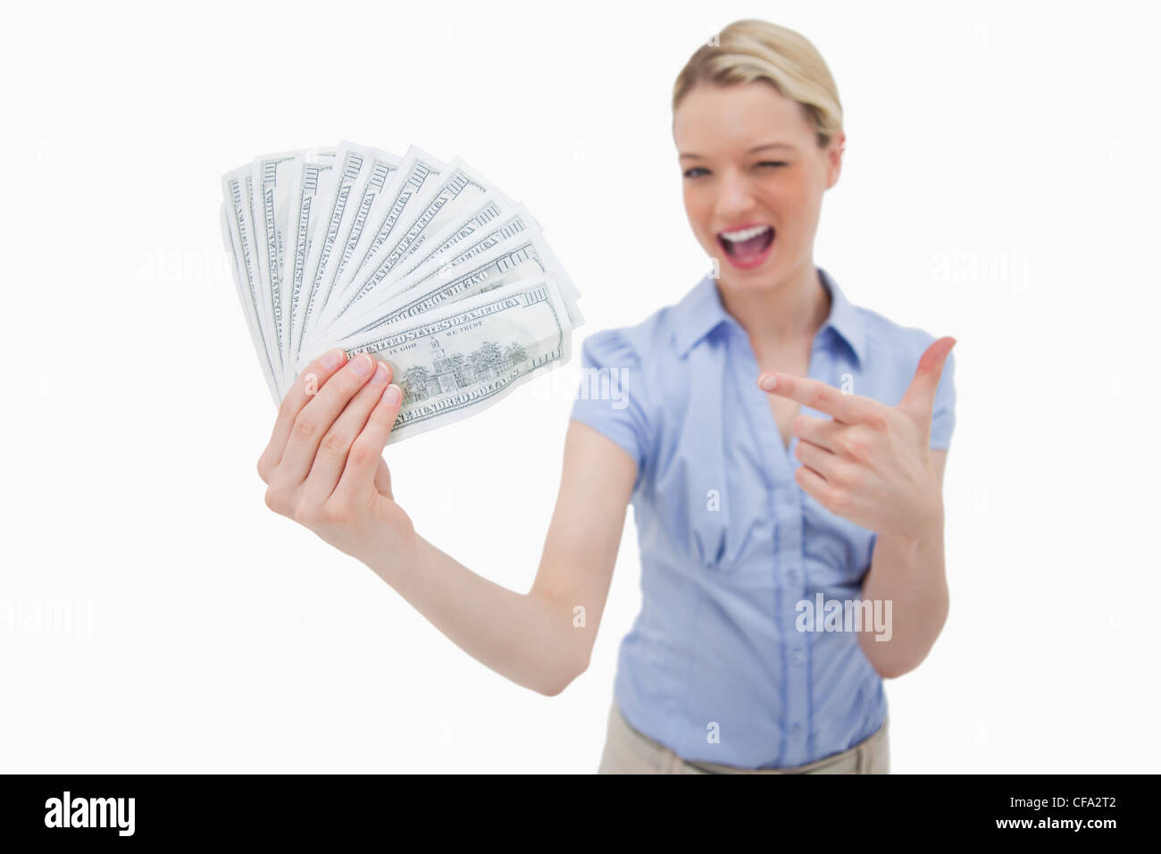 Woman holding money and pointing at it Stock Photo