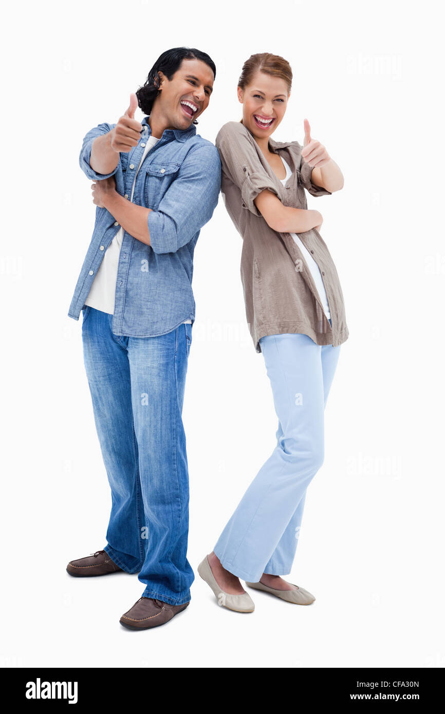 Smiling young couple giving thumbs up Stock Photo