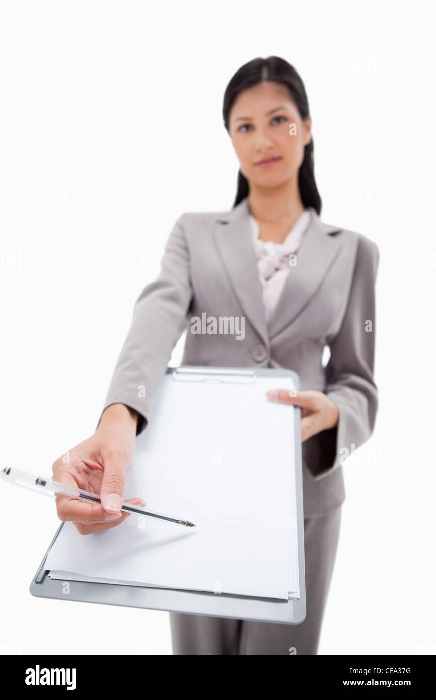 Clipboard and pen being handed over by businesswoman Stock Photo