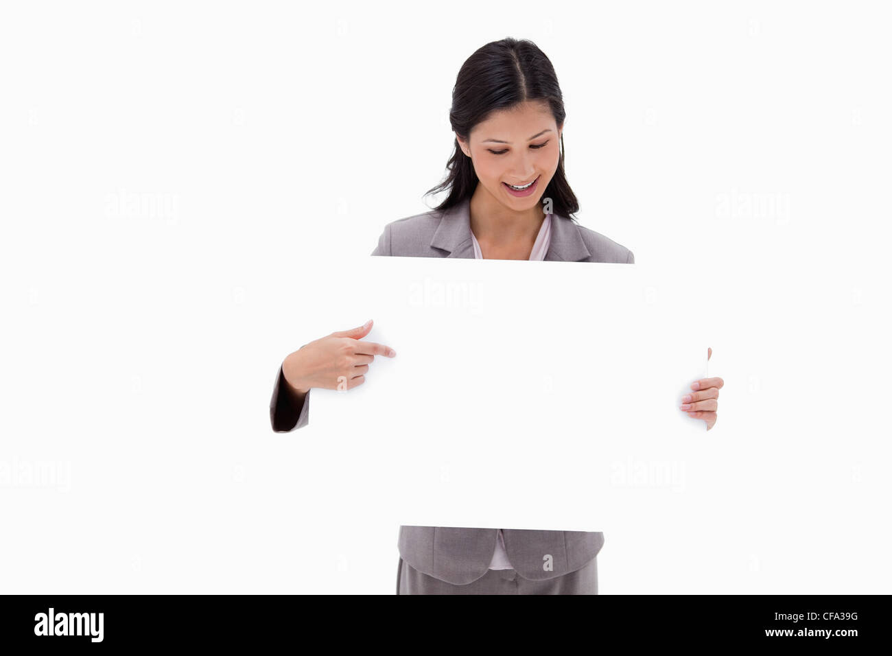 Businesswoman looking and pointing at blank sign board Stock Photo
