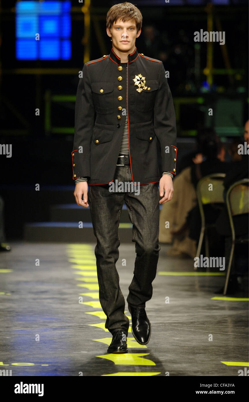 Gas Menswear Milan A W Brunette male wearing a black military jacket red  piping and gold buttons Worn a striped T shirt, black Stock Photo - Alamy