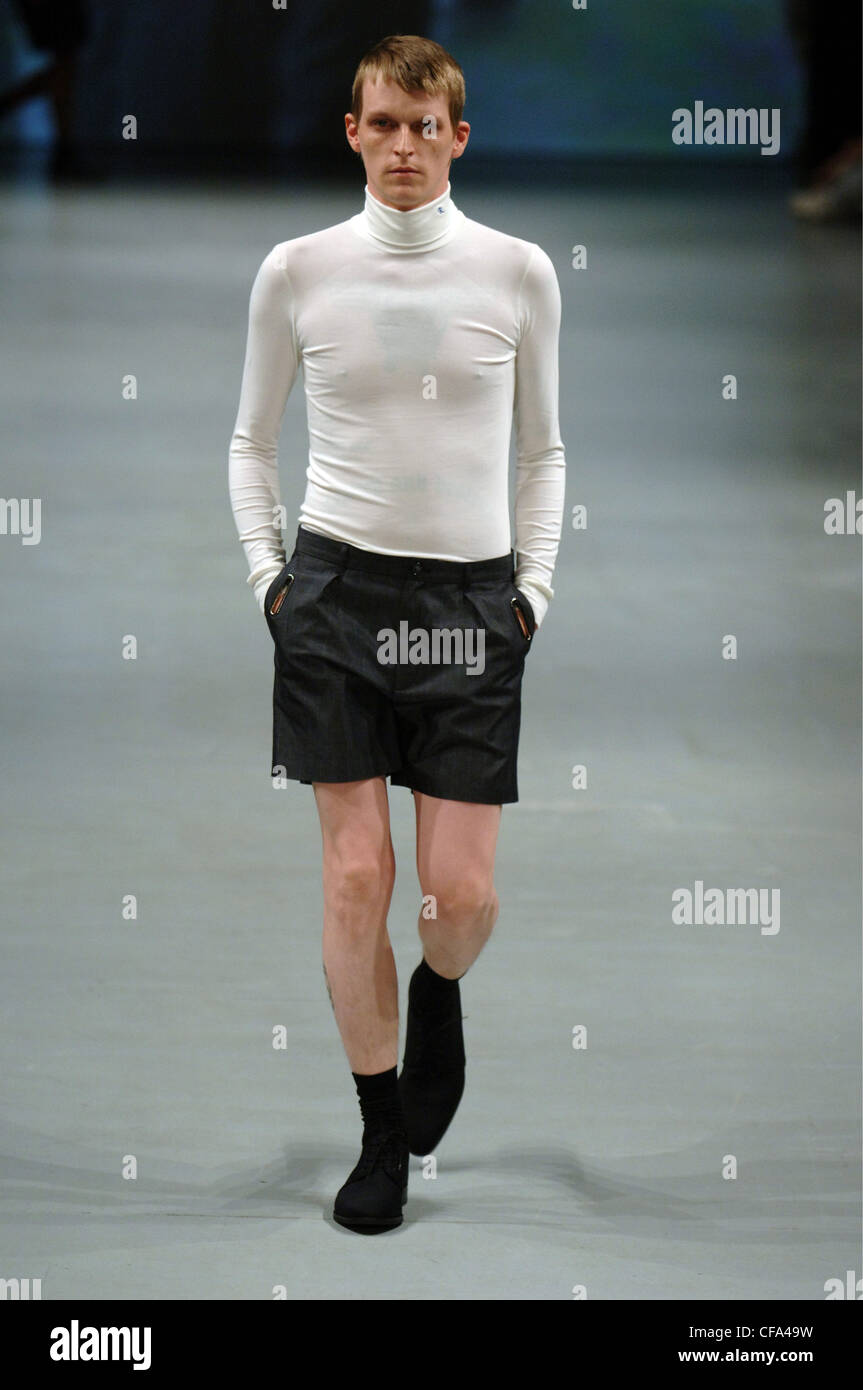 Raf Simons Paris Ready to Wear Menswear Spring Summer Blonde male model wearing a skin tight long sleeved high neck sweater and Stock Photo